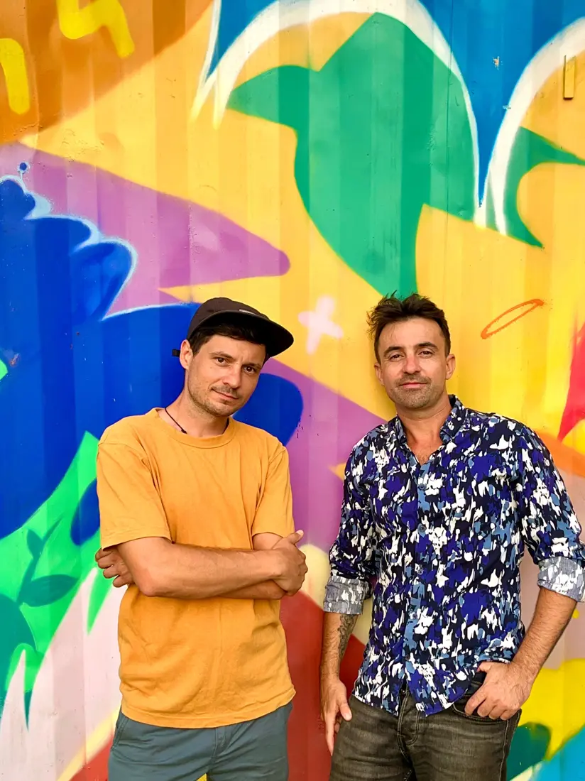 Le duo devant une fresque colorée
