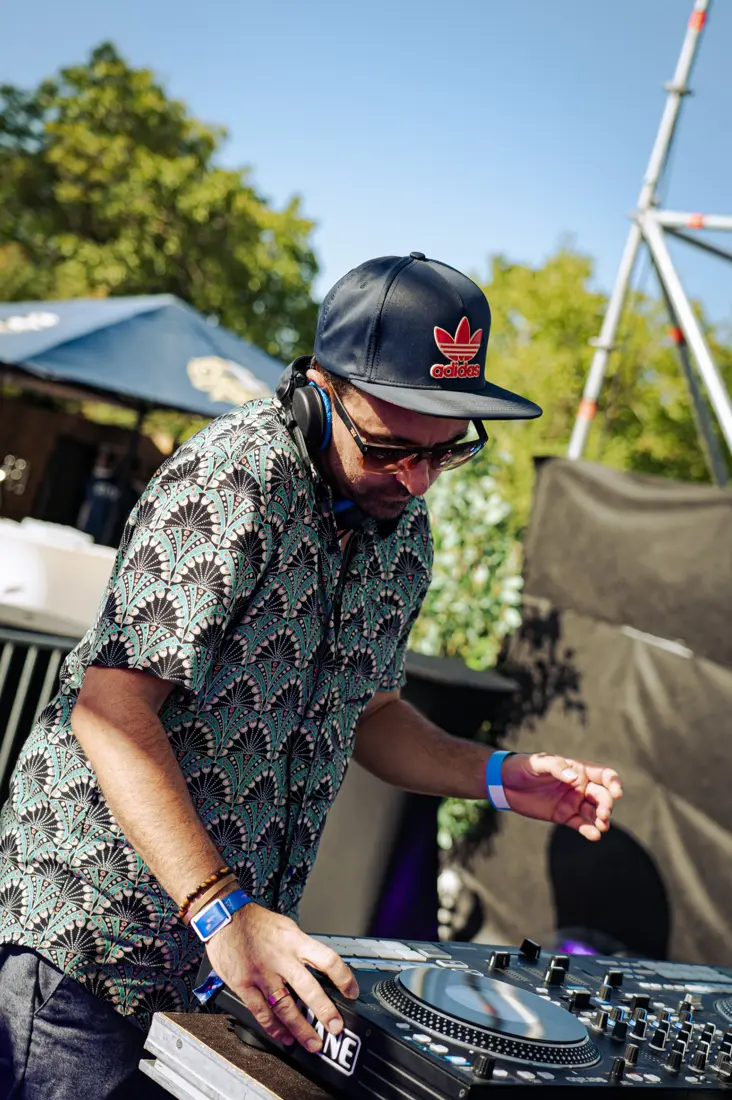 Un des DJs penché sur ses platines en plein soleil